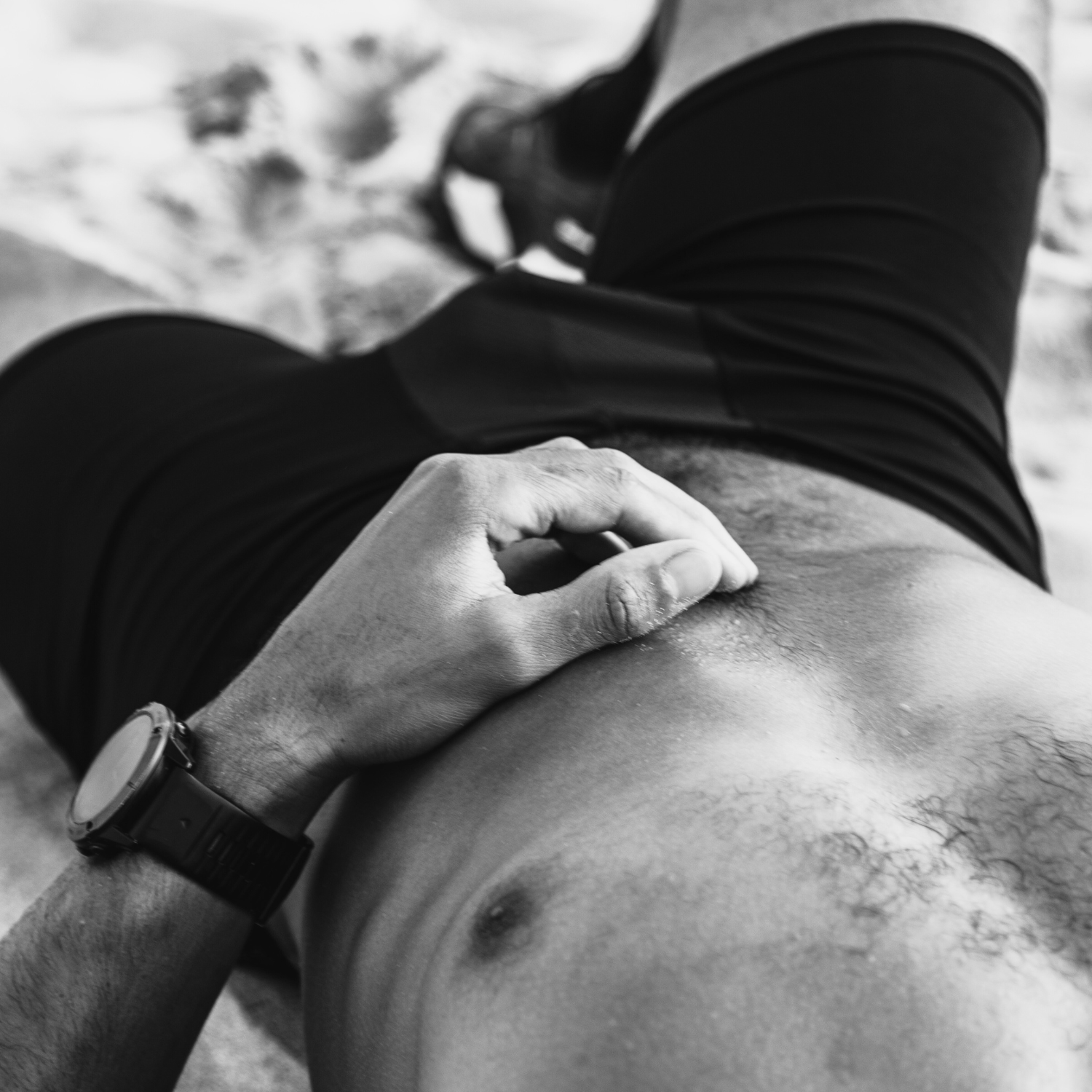 Close-up of a person wearing ruhn performance underwear in Activated Black while laying on sand