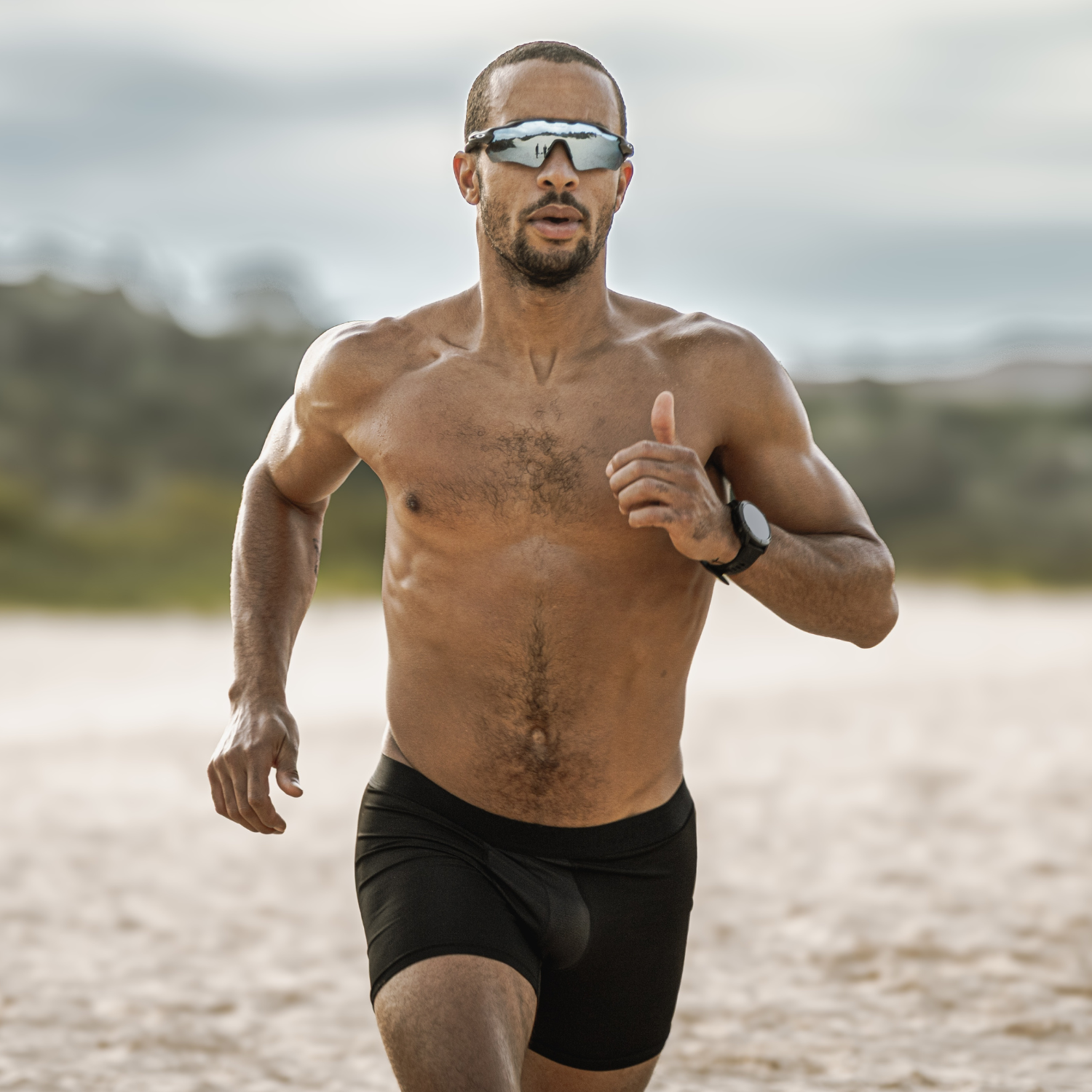 Man running on a beach wearing ruhn activated black performance underwear from the Agility Collection